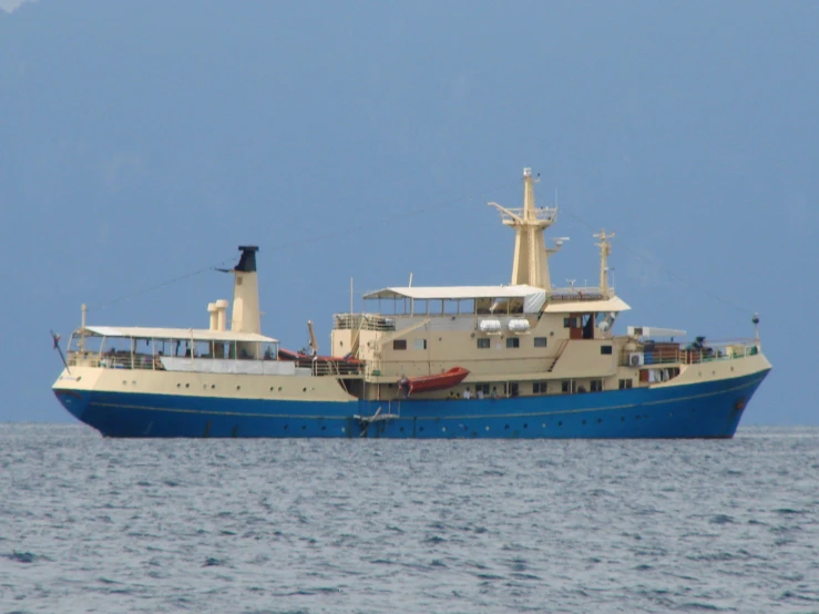 a boat in the middle of the ocean is a large and blue boat with a few people