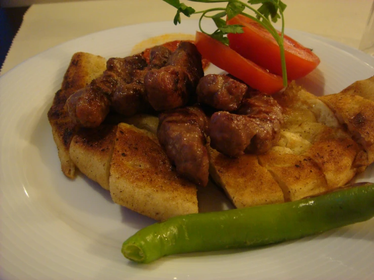 the meat is on a plate next to green peppers