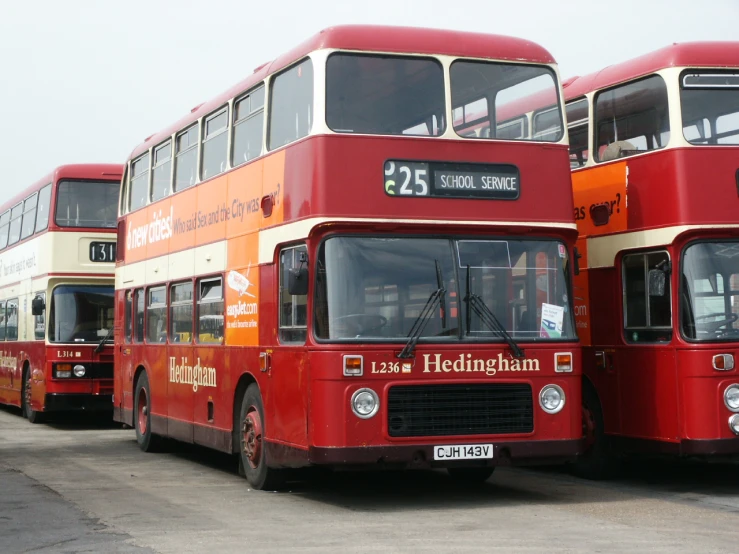 four double decked buses sitting in a line on the street