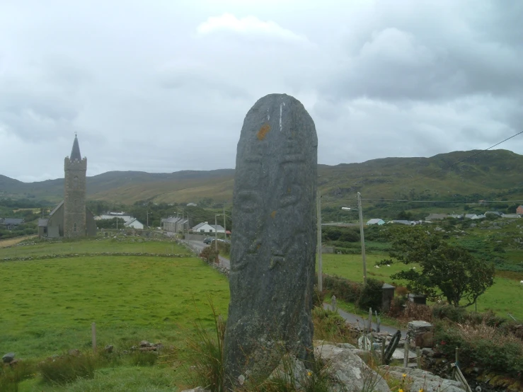 a monument sits in the grass near a large grassy field