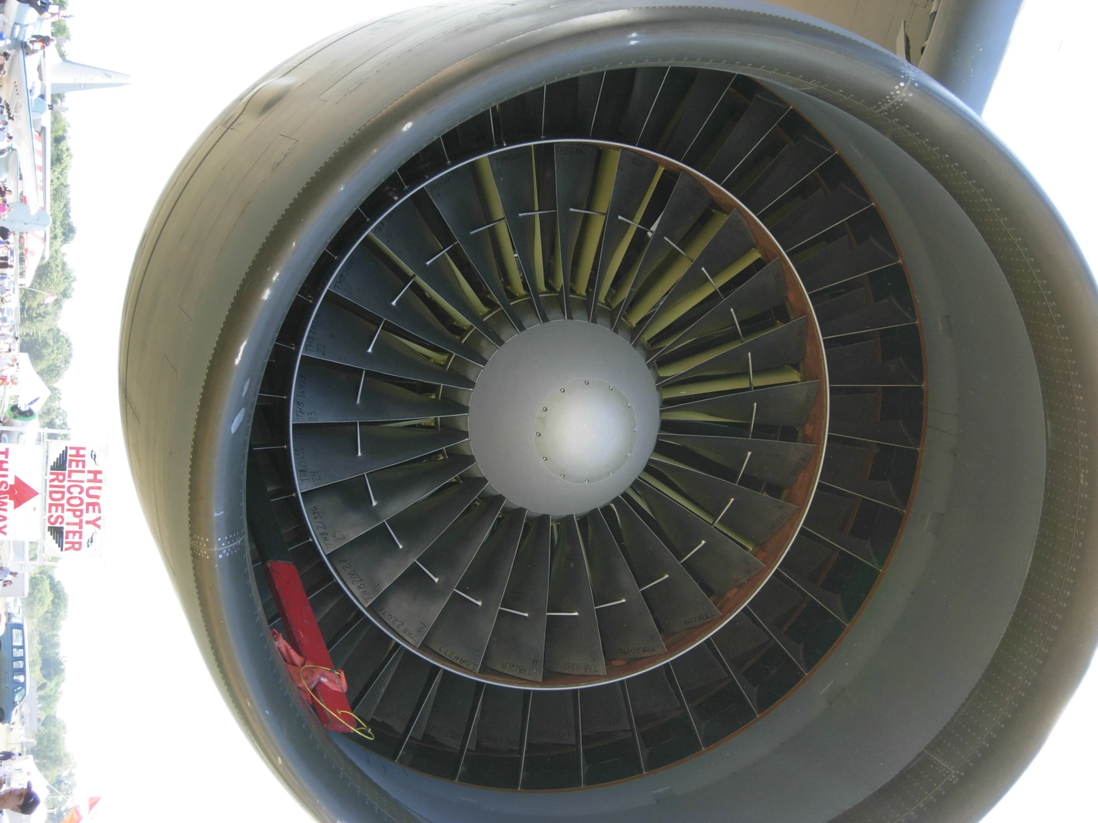 the underside of an airplane's engine with people in the background