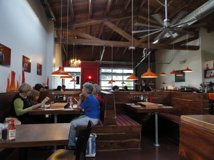 a couple of women sitting at wooden booths