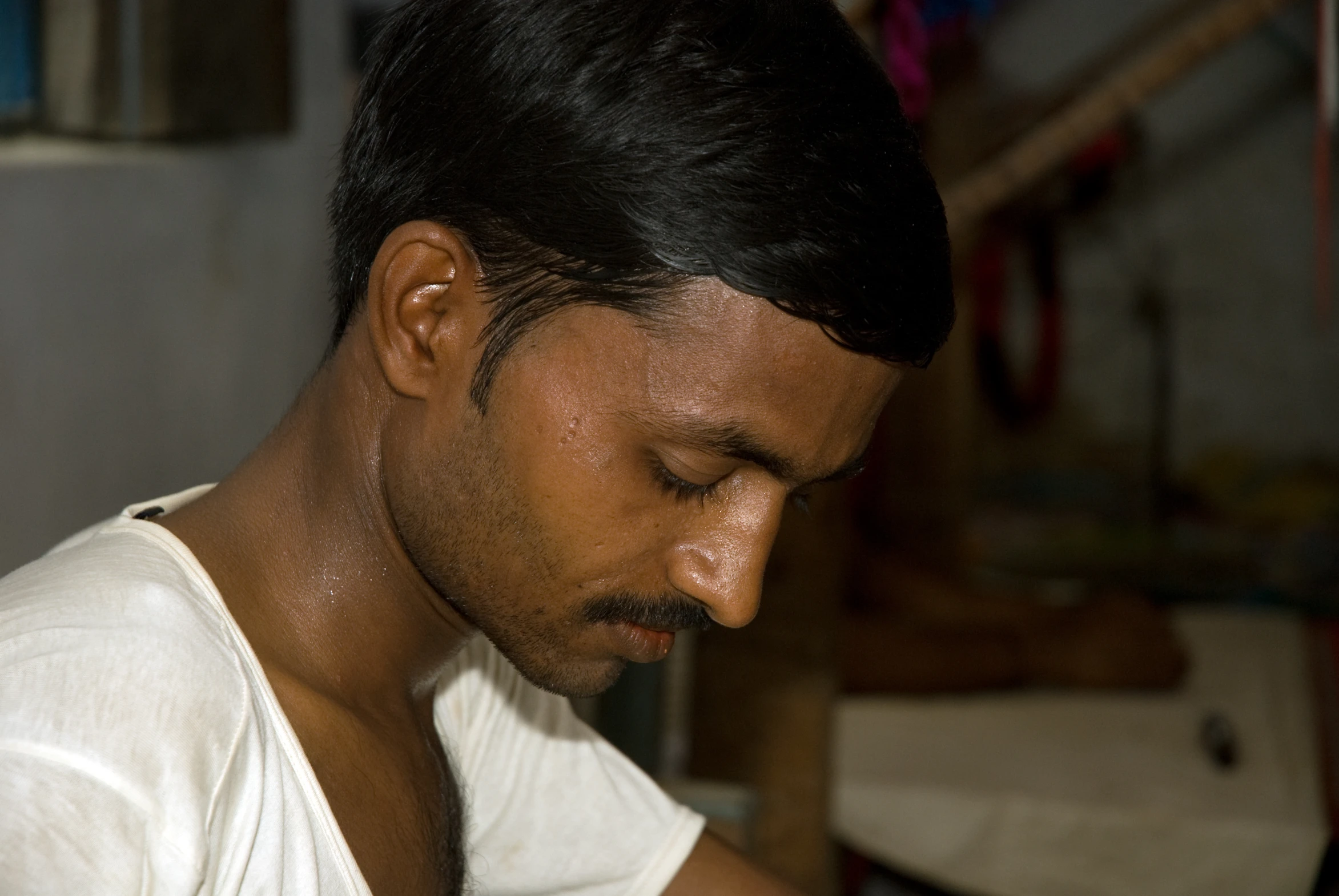 a man with a moustache is looking down