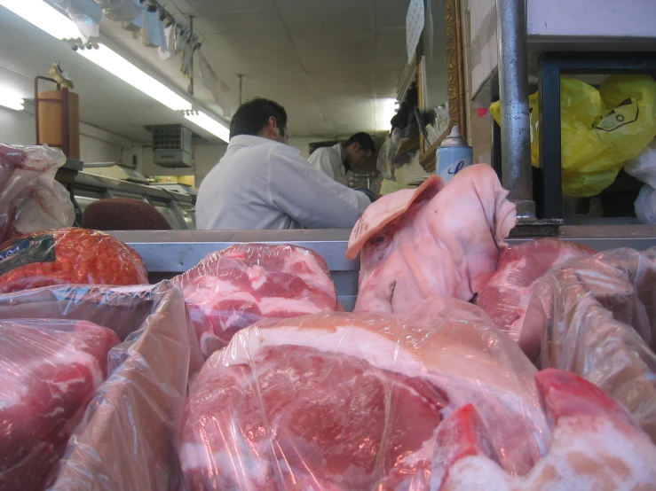 workers work in the kitchen area where meat is prepared