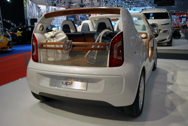 a white car parked on top of a floor covered in a white carpet