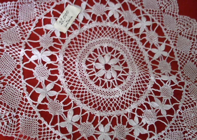 white lace is laying across a red background