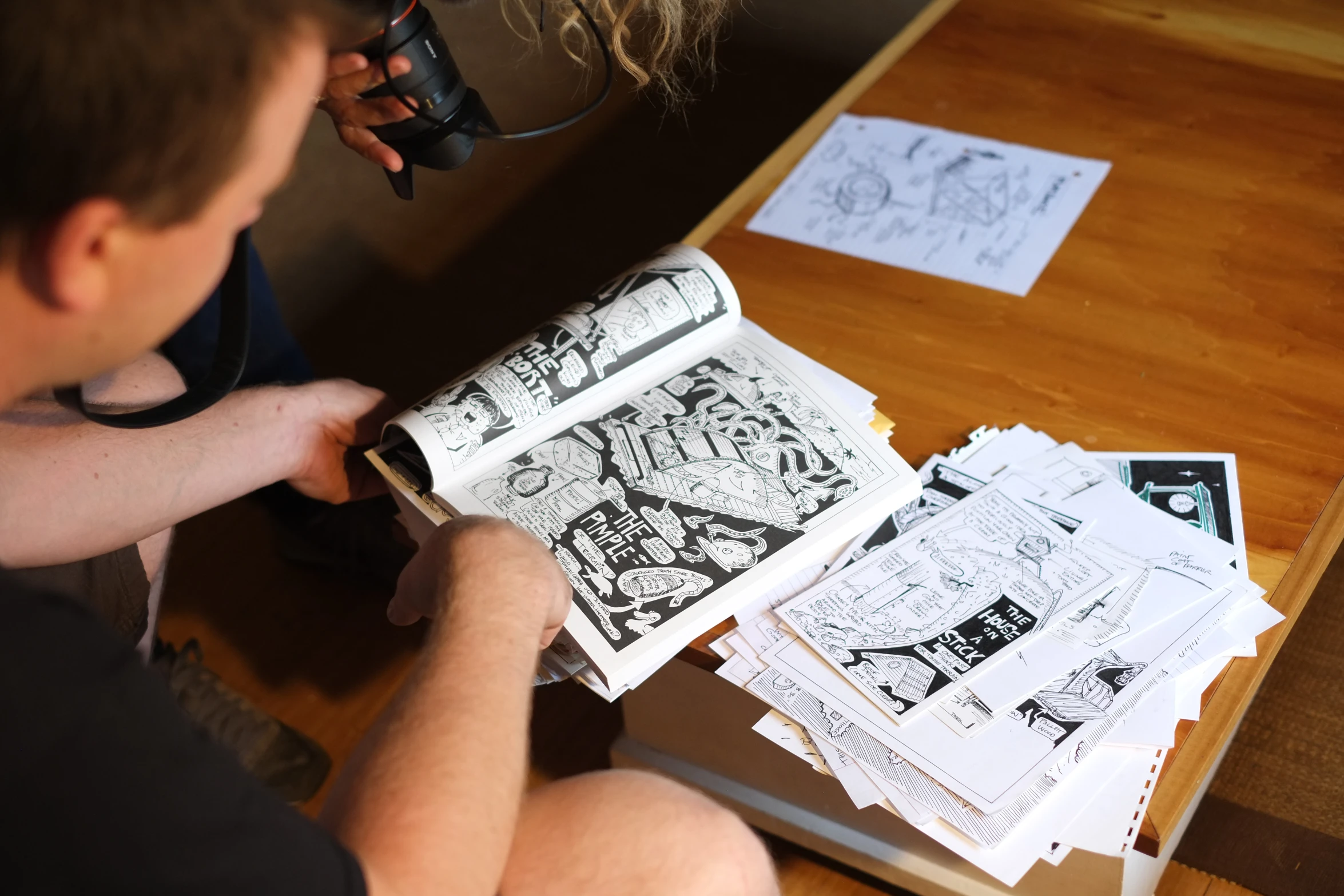 a boy is making comics with some paper