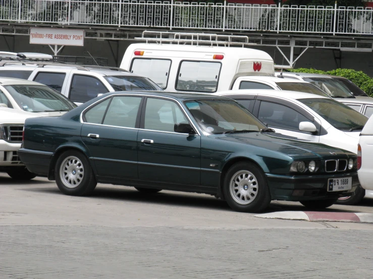 there is a green bmw on the side of the street