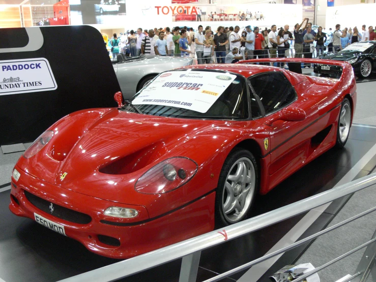 a red sports car that is on display in a building