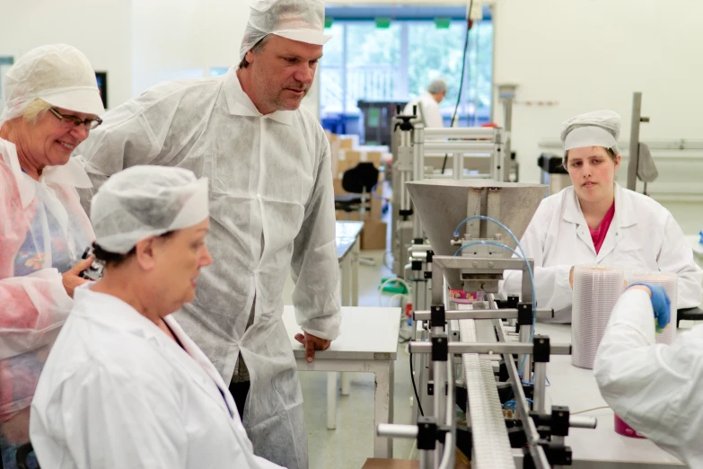 several people standing and sitting in a factory