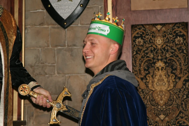 a man holding a golden crown and two other pieces of gold