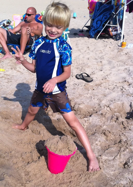 the  is standing on the beach with his toys