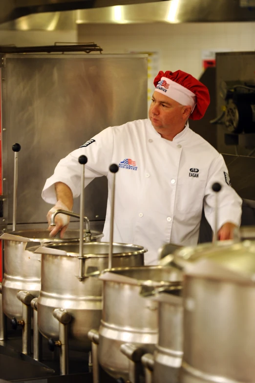 a man in white shirt and chefs outfit making food