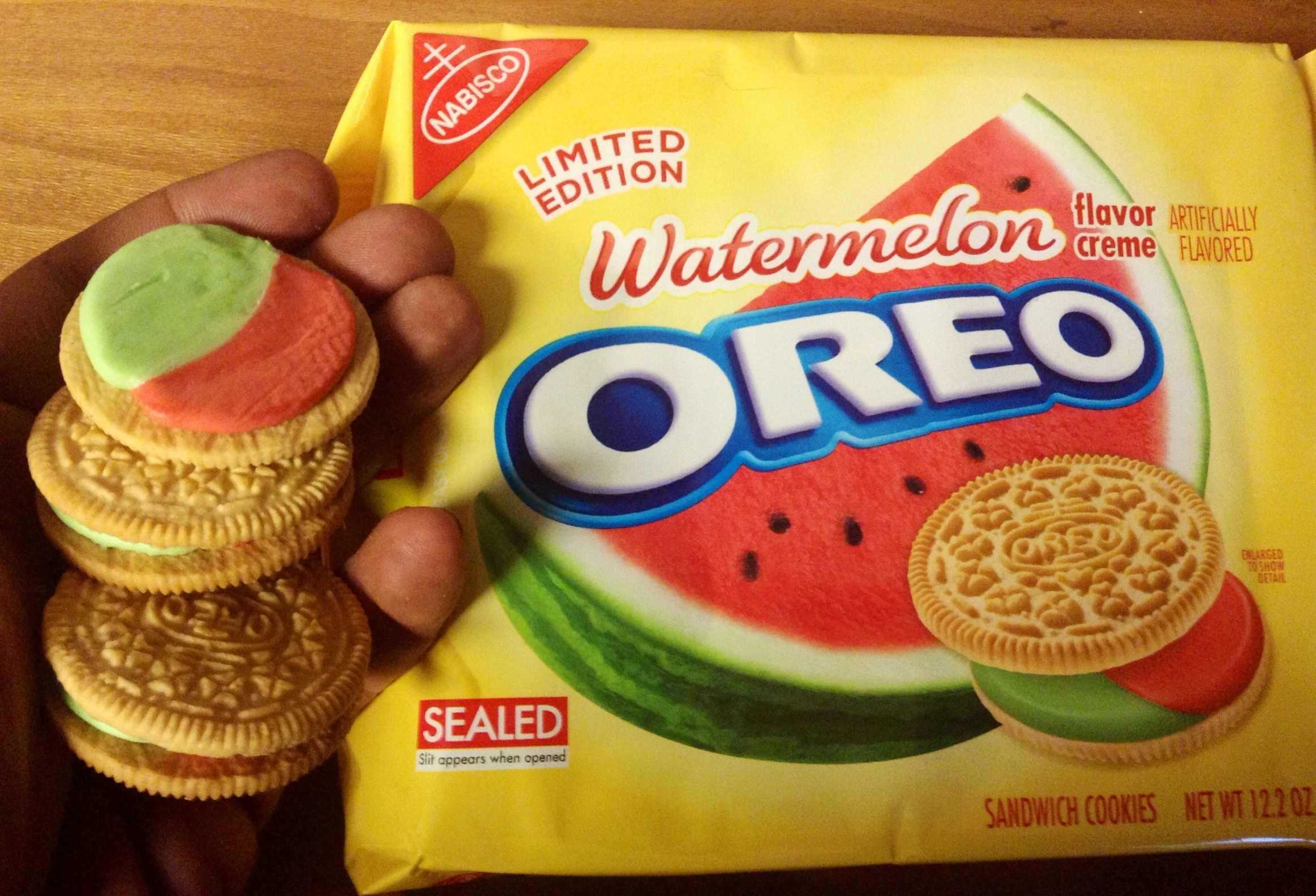 a person holding up a box of watermelon oreos