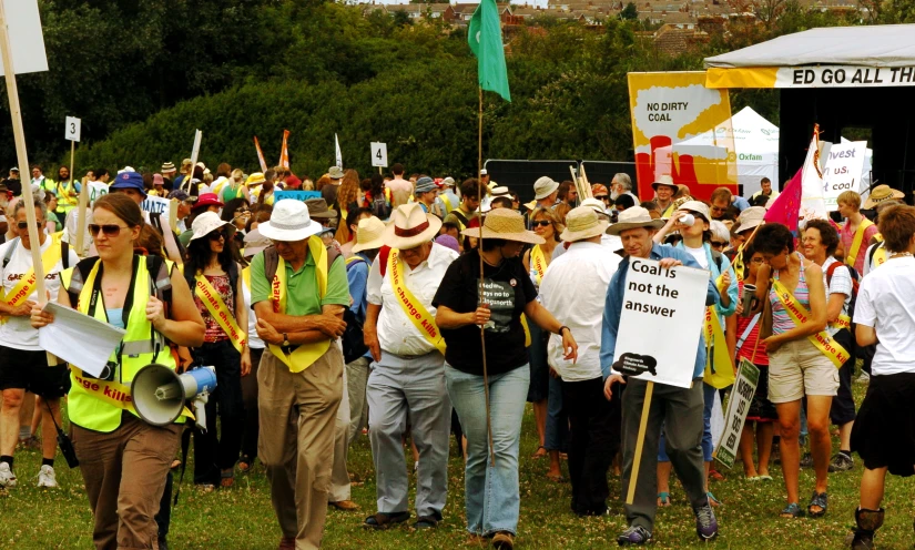 the crowd is standing outside holding signs