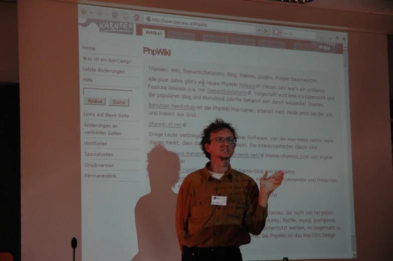 a person giving a lecture in front of a projector screen