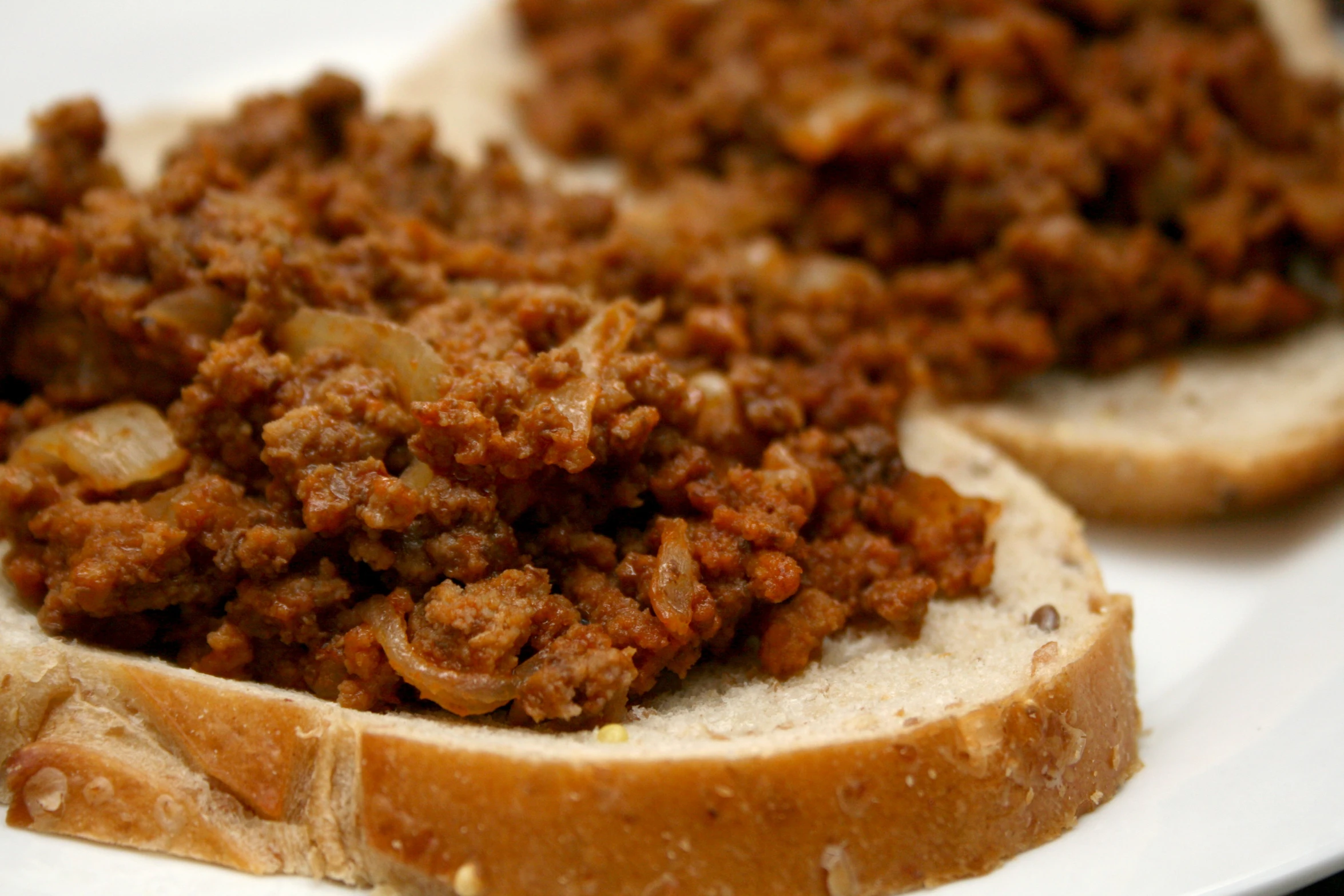 sloppy joes are sitting on the side of a white plate