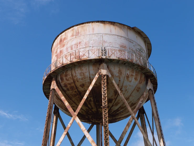 a tall rusted water tower against a blue sky