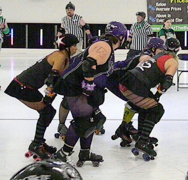 people in black costumes are skating on the ice