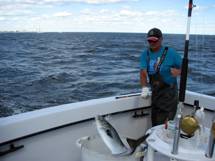 a man on the back of a boat holding a fish