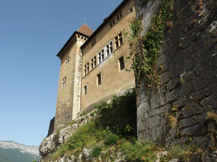 an old castle with stone walls and brick windows