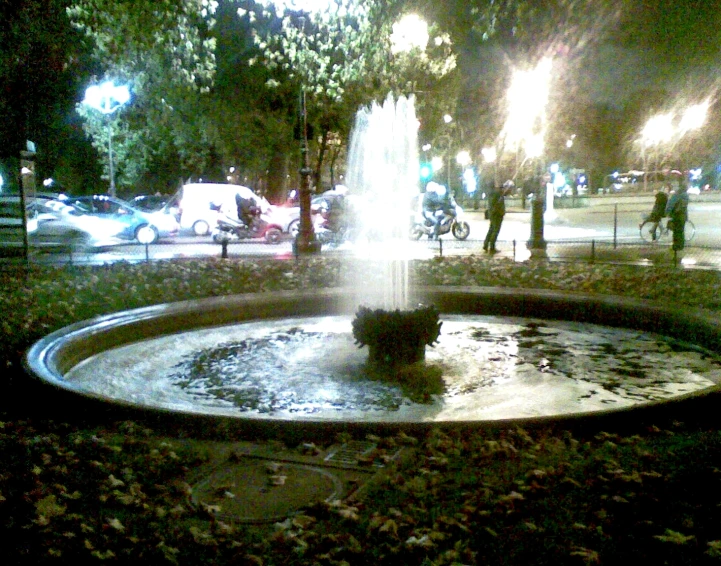 a water fountain in the middle of a park