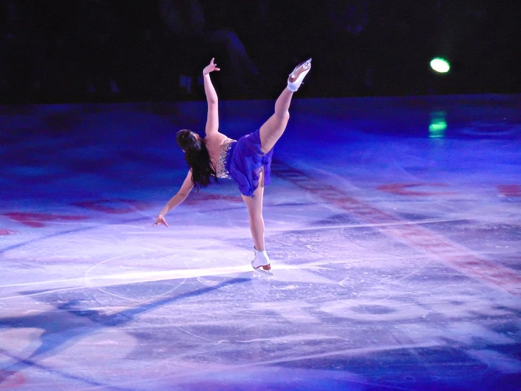 a woman is in the air on an ice rink