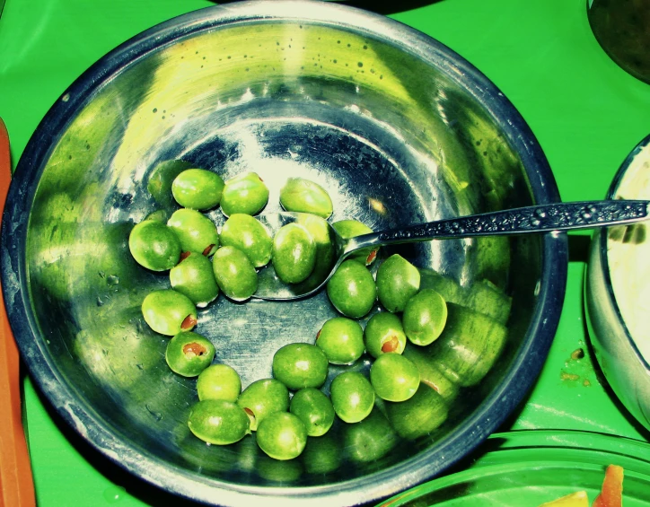 olives and other food sitting in bowls with a fork