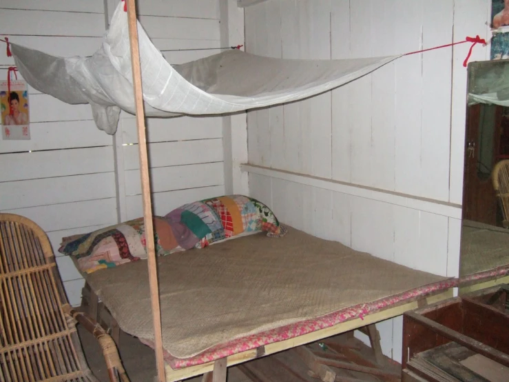a bed has four wooden rails and a canopy over it