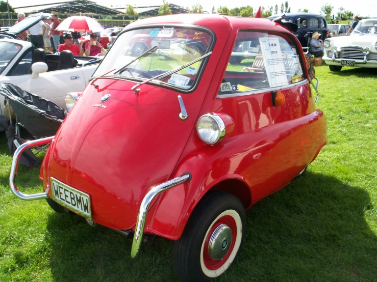 old cars sitting on grass at an event