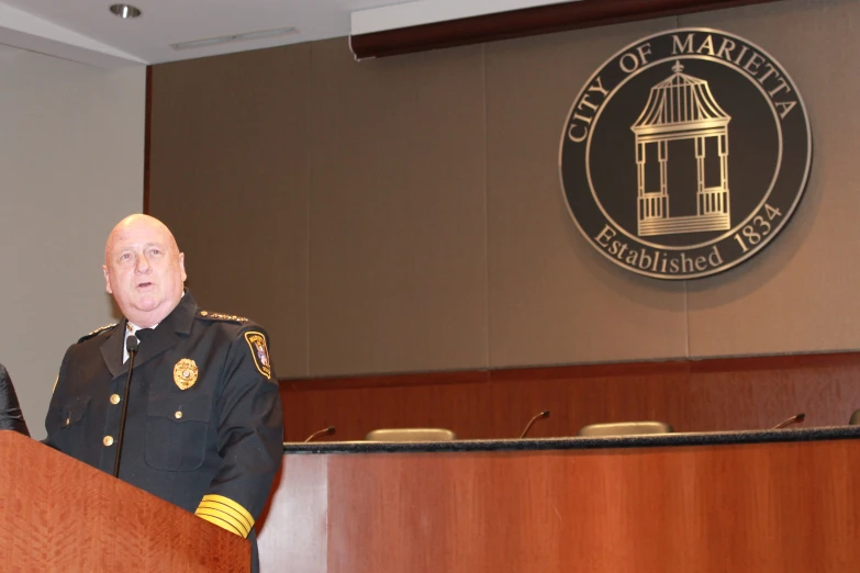 a man in uniform stands behind a podium