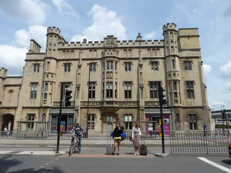 three people crossing the street in front of a large building