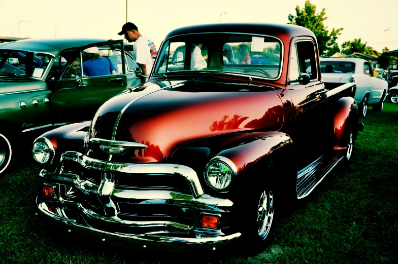 an old fashioned car parked next to other vintage cars