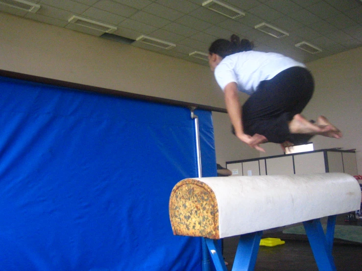 the woman is jumping over a long bar on a board