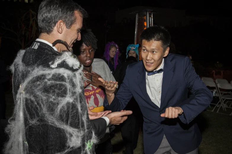 two men and one is wearing a suit and tie