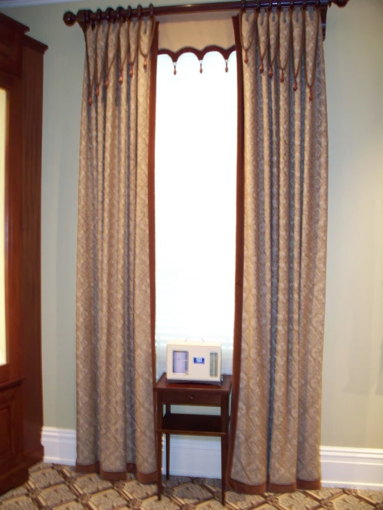 there is a window with curtains closed with a little table in the corner