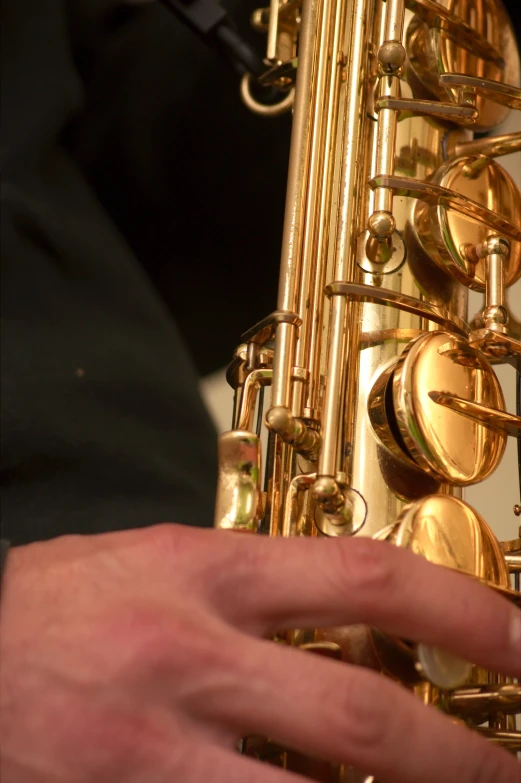 man playing a golden saxophone against white background