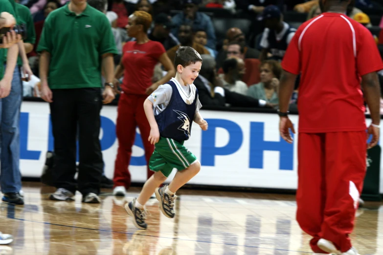 a young man running down the court in front of other men