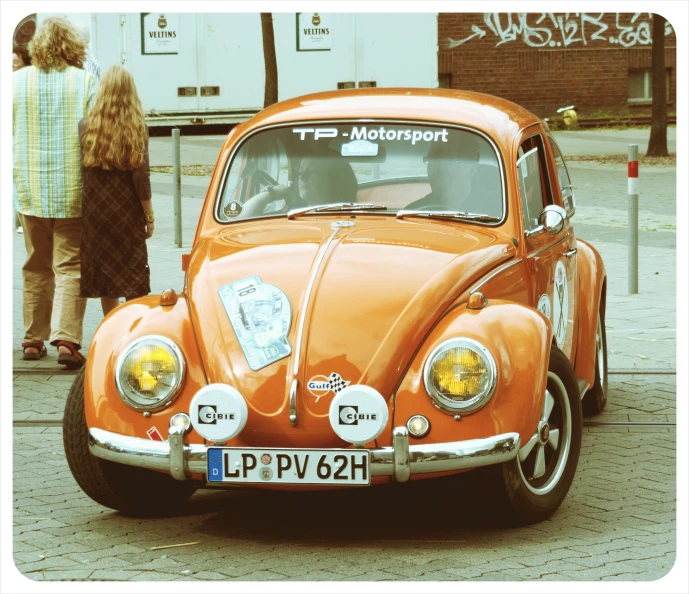 an orange car that is parked on the street