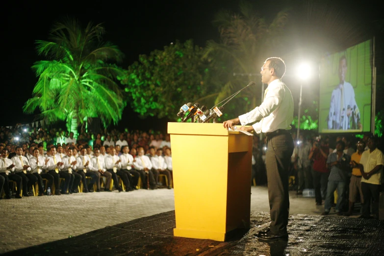 a man stands at a podium and speaks to people