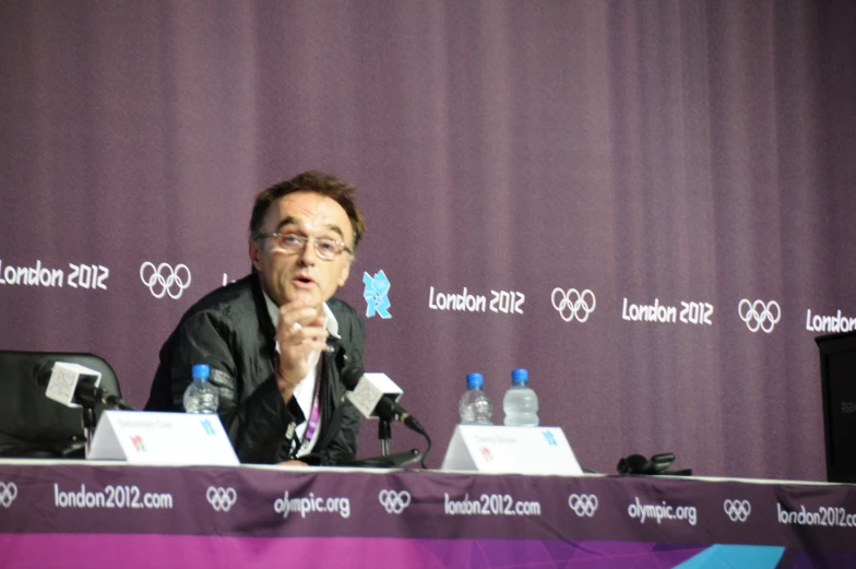 a man at a press conference has a microphone to his side