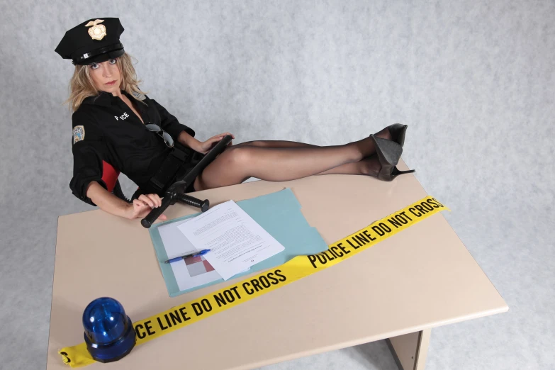 a woman in police uniform sitting on top of a desk