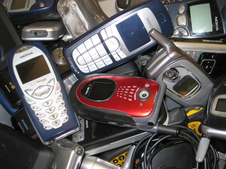 a pile of old cell phones and other electronic gadgets