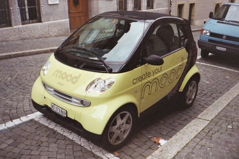 a small car is parked on a cobblestone street