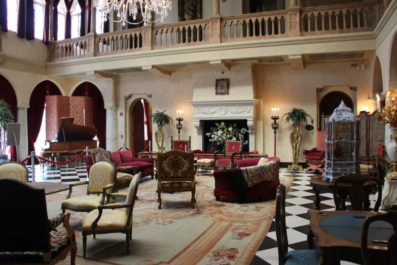 a room with furniture, large chandelier and ornate columns