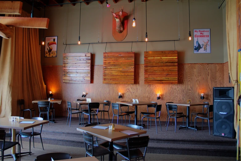 two deer heads hanging from a wall over tables in a restaurant