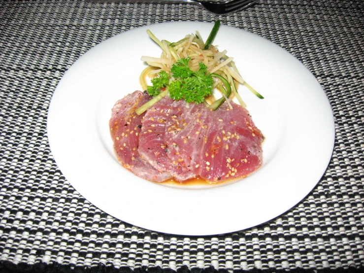 meat with vegetables on the side sitting on a plate