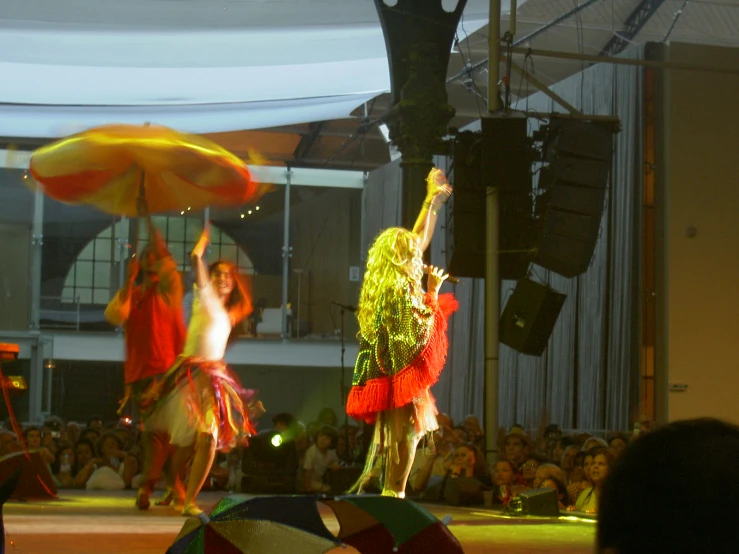 several dancers in costume performing on stage at night