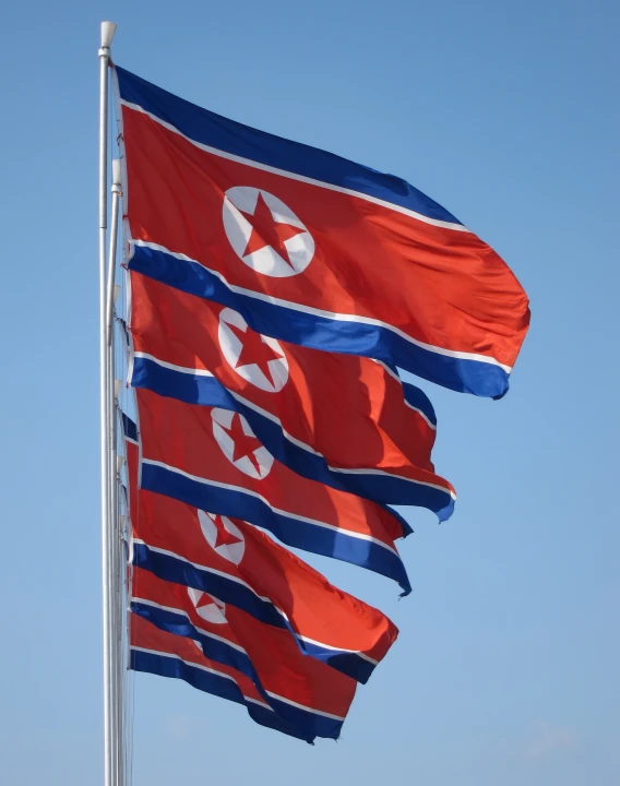 three flags flying in the wind together