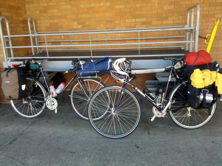 three bicycles parked side by side with bags on the back